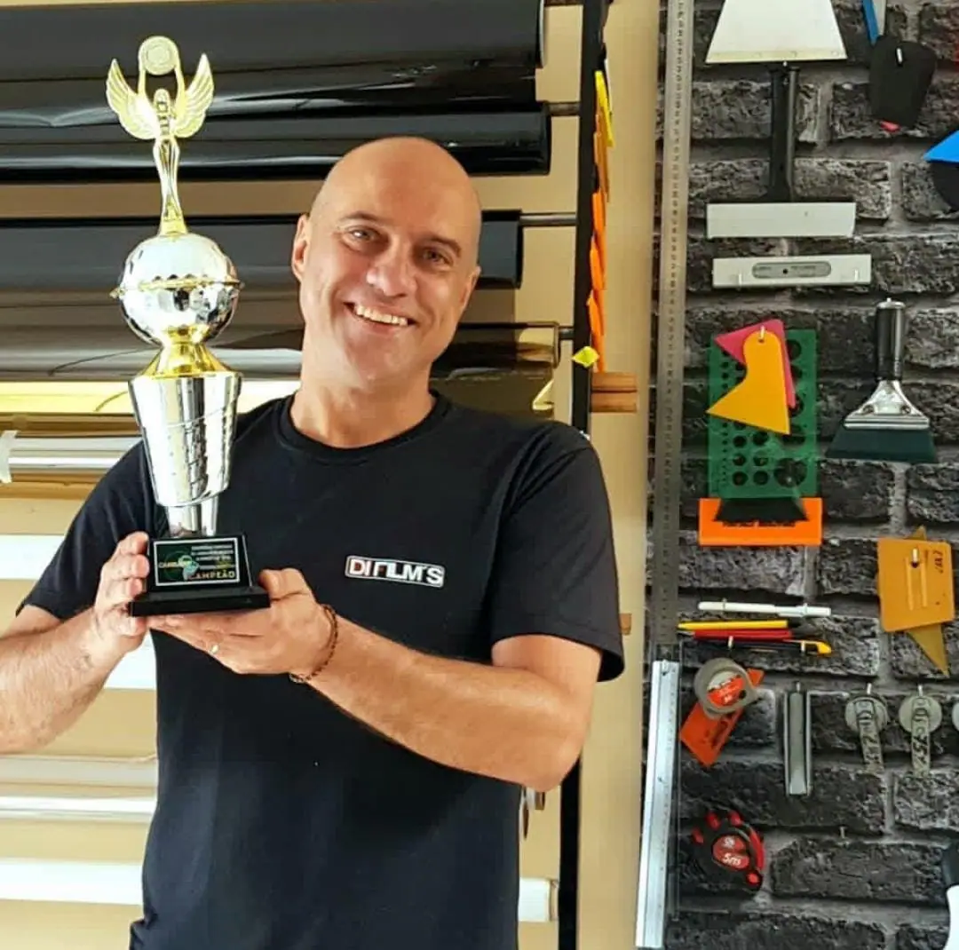Instalador da Di Films com troféu de campeão de aplicação de películas